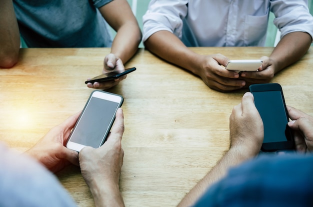 Group of friends or young people hands using smart phone playing social networking 