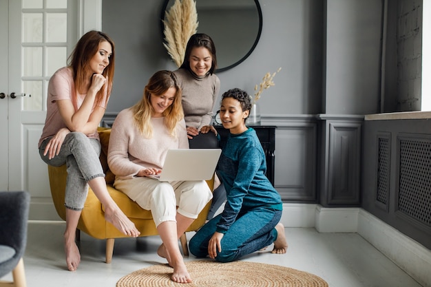 A group of girlfriends watch the series on a laptop