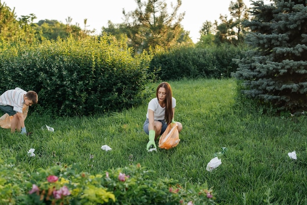 A group of girls with children at sunset are engaged in garbage collection in the park Environmental care recycling