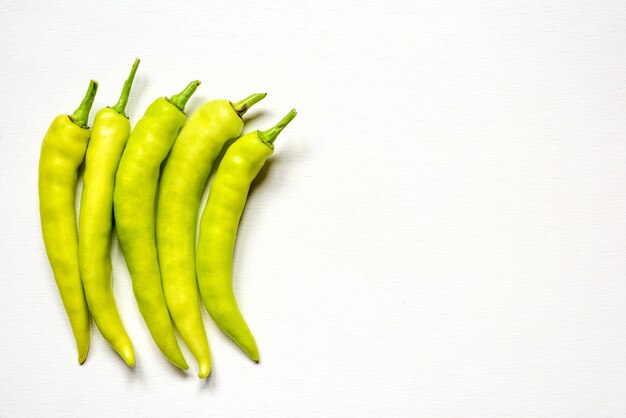 Group of green peppers  on white wooden backgroundhas copy space