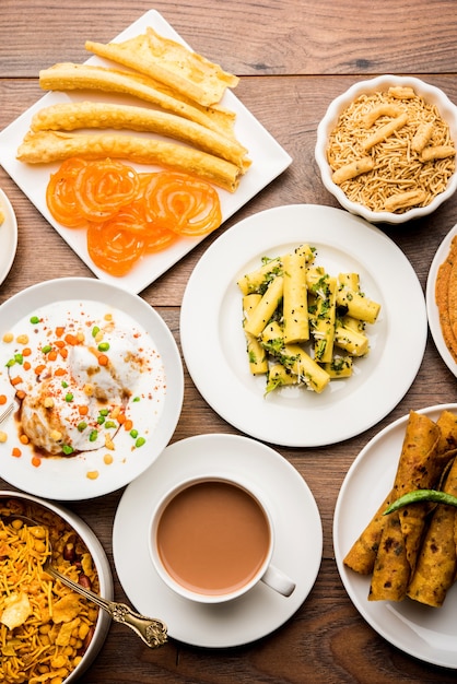 Group of Gujarati snacks like jalebi-fafda, thepla, khaman dhokla, aloo bhujiya, khandvi,khakra, dahi vada, gathiya with hot tea