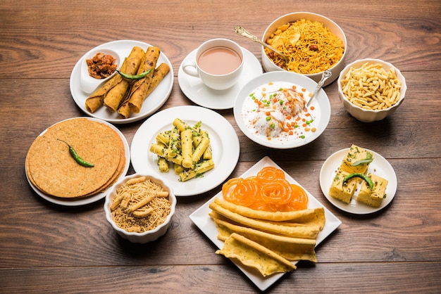 Group of Gujarati snacks like jalebi-fafda, thepla, khaman dhokla, aloo bhujiya, khandvi,khakra, dahi vada, gathiya with hot tea