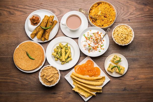 Group of Gujarati snacks like jalebi-fafda, thepla, khaman dhokla, aloo bhujiya, khandvi,khakra, dahi vada, gathiya with hot tea