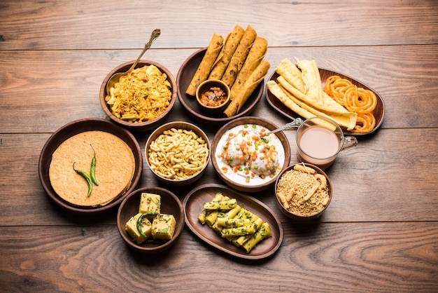 Group of Gujarati snacks like jalebi-fafda, thepla, khaman dhokla, aloo bhujiya, khandvi,khakra, dahi vada, gathiya with hot tea