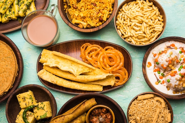 Group of Gujarati snacks like jalebi-fafda, thepla, khaman dhokla, aloo bhujiya, khandvi,khakra, dahi vada, gathiya with hot tea