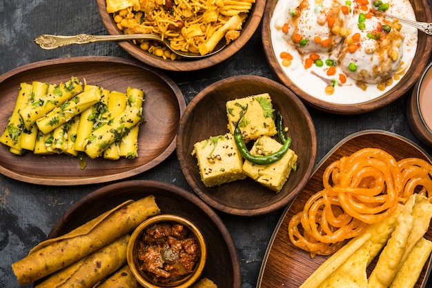 Group of Gujarati snacks like jalebi-fafda, thepla, khaman dhokla, aloo bhujiya, khandvi,khakra, dahi vada, gathiya with hot tea