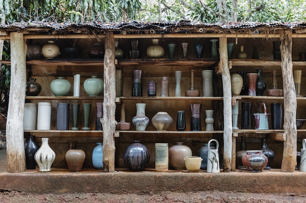 Group of handcraft ceramic kitchenwares arranged on shelves