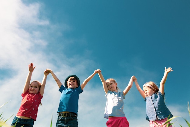 A group of happy children of boys and girls run in the Park on the grass on a Sunny summer day  The concept of ethnic friendship peace kindness childhood