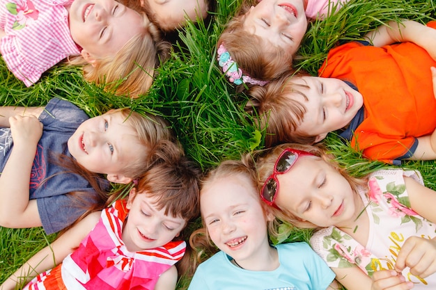 A group of happy children of boys and girls run in the Park on the grass on a Sunny summer day . 