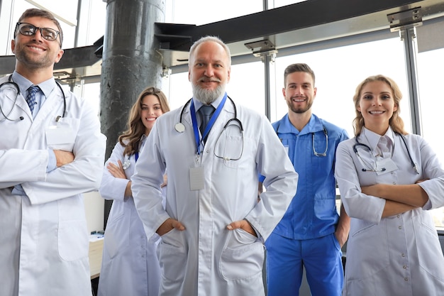 Group of happy doctors in hospital corridor, portrait.