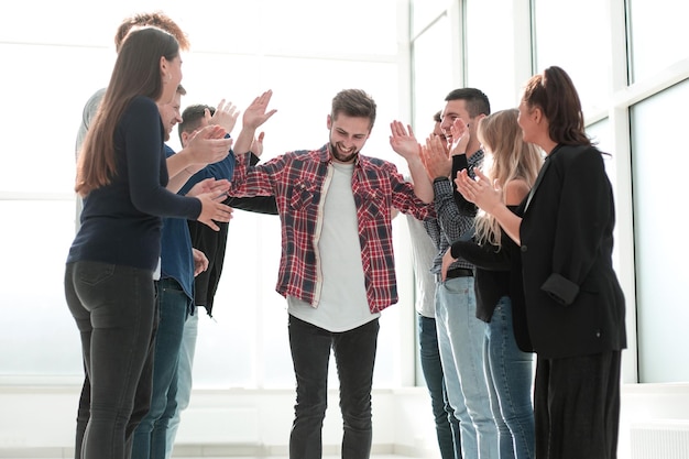 Group of happy employees congratulating their colleague