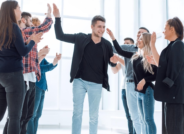 Group of happy employees congratulating their colleague