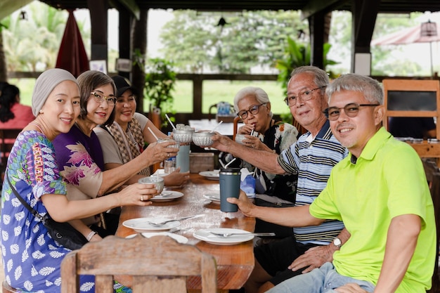 Group of happy family having lunch and making a toasting at restaurant