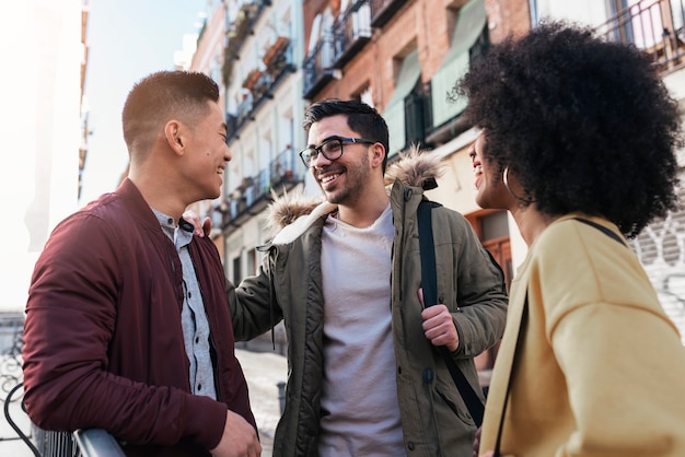 Group of happy friends chatting in the street. Friendship concept.