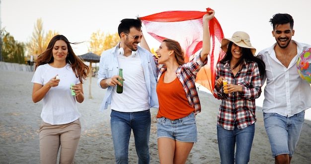 Group of happy friends partying on beach and having fun