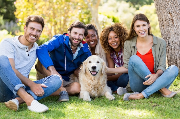 Group of happy friends sitting together with the dog