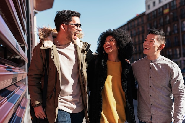 Group of happy friends walking in the street. Friendship concept.