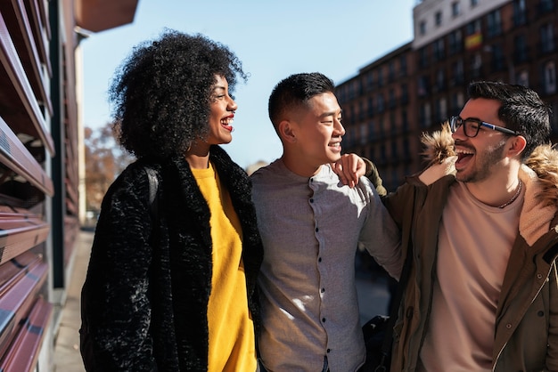 Group of happy friends walking in the street. Friendship concept.