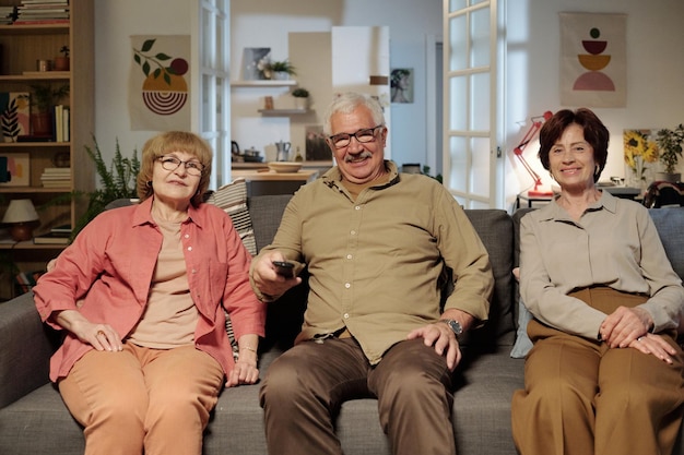 Group of happy senior friends in casualwear sitting on comfortable couch