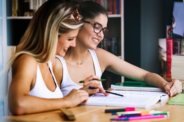 Group of happy university students studying in the college library