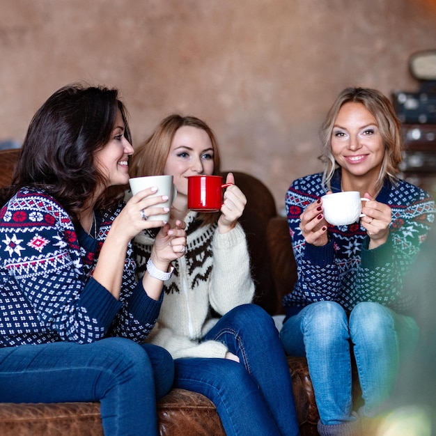 Group of happy women chatting while drinking coffee at home