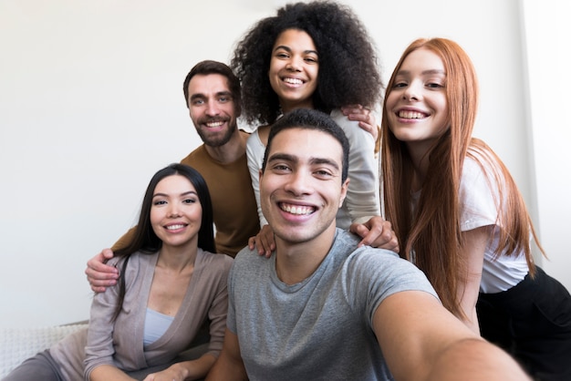 Photo group of happy young people taking a selfie