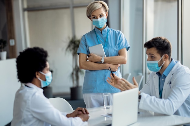 Group of healthcare workers talking while working in the hospital during coronavirus pandemic