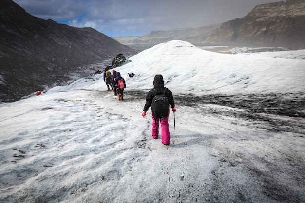 Group of hiker walk on glacier during heavy snow fall on Solheimajokull