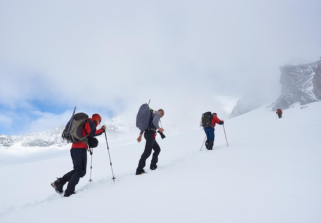 Group of hikers climbing the hill covered with snow