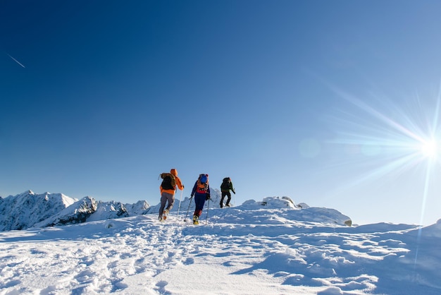 Group hikers in winter mountains beautiful landscape and blue sky