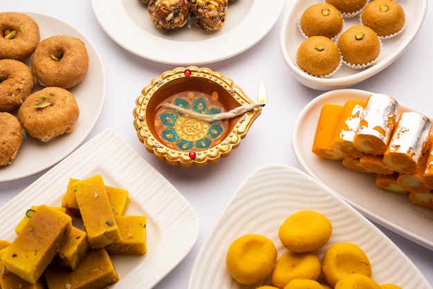 Group of Indian assorted sweets or mithai with diya