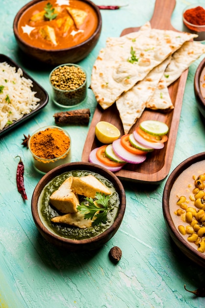 Group of Indian food like Palak Paneer Butter Masala, Choley or chola and Black Eyed Kidney Beans curry with Naan and Rice