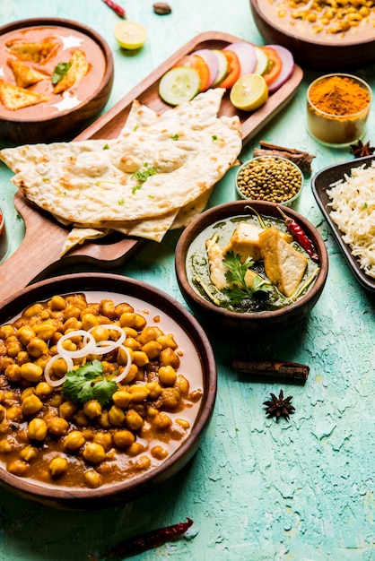 Group of Indian food like Palak Paneer Butter Masala, Choley or chola and Black Eyed Kidney Beans curry with Naan and Rice