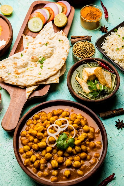 Group of Indian food like Palak Paneer Butter Masala, Choley or chola and Black Eyed Kidney Beans curry with Naan and Rice