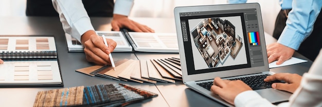 Group of interior architect designer team at table choosing various mood board samples with architecture software on laptop screen Modern renovation and interior material selection concept Insight