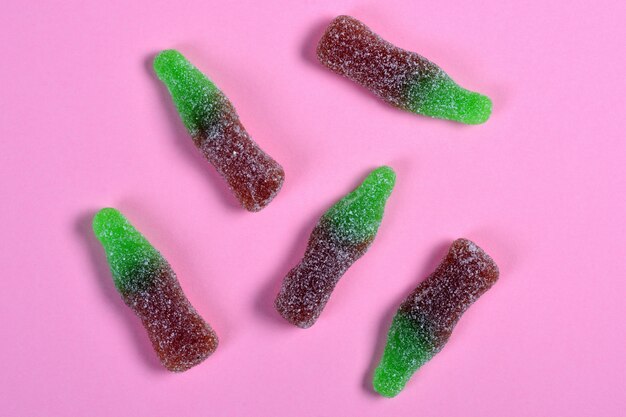 Group of jelly candies coke bottles on pink 