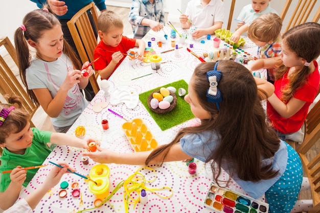 Group of kids painting Easter eggs. Master class for children of different ages