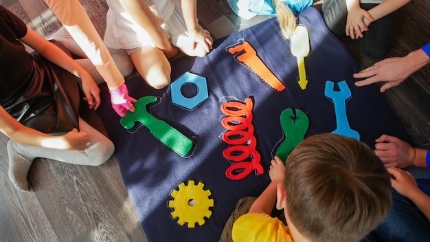 Photo group of kids playing with structured puzzle view from above