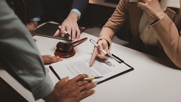 A group of lawyers is discussing contract documents that must be presented to a client Lawyers brainstorm to revise important documents that must be submitted to the Supreme Court