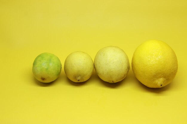 Photo group of lemons on yellow background