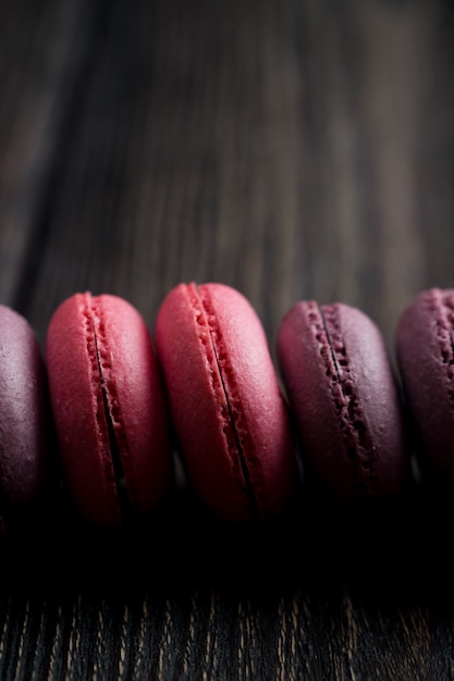 Group of macarons made of strawberries, cream, chocolate and blueberries. Rustic photo.