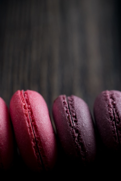 Group of macarons made of strawberries, cream, chocolate and blueberries. Rustic photo.