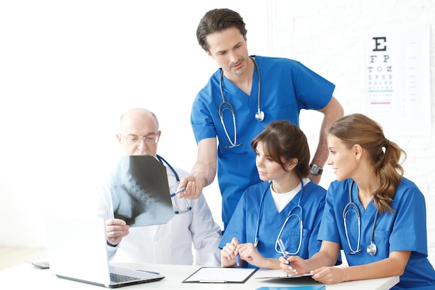 Group of medical doctors and nurses looking at Xray in office