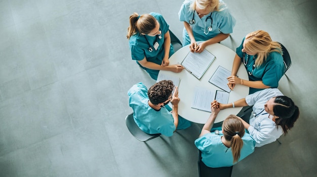 Photo a group of medical students sitting at a table with a tablet and notebooks