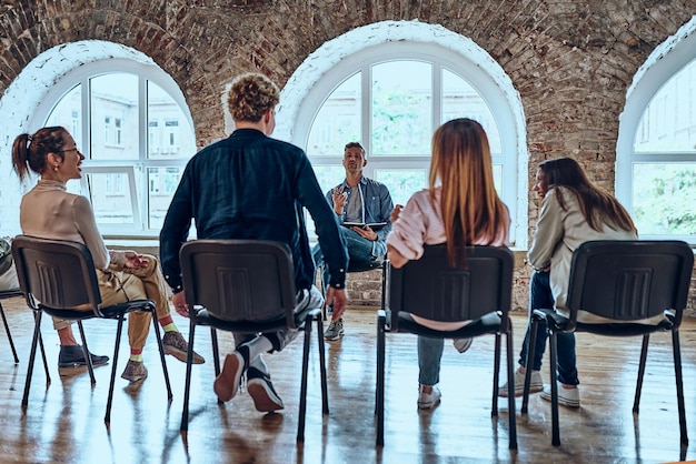 Group meeting with counselor for people trying to gain life balance Back view Selective focus