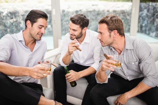 Group of men smoking and drinking while discussing