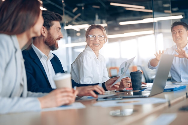 Group of modern lawyers businesspeople and investors gather at the table in corporate meeting room