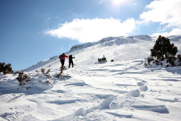 Group of mountaineers walking trough the mountains covered with snowxAxA