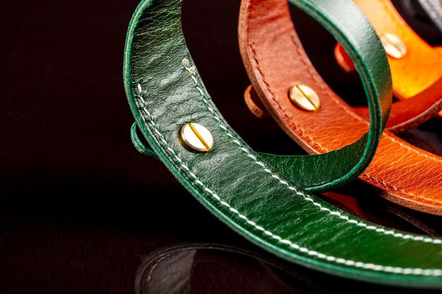 A group of multicolored leather belts on a black background