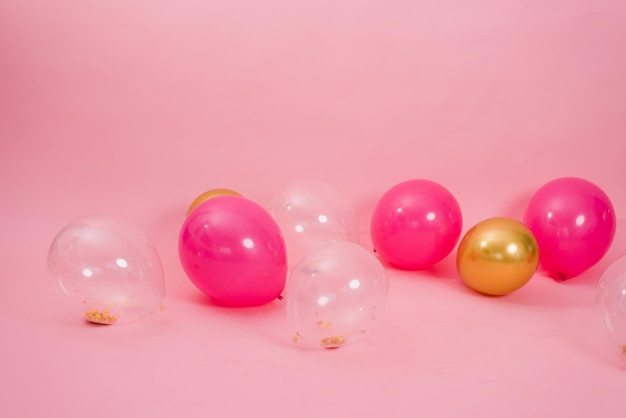 Group of multicolored transparent pink and gold balloons lying on the floor in the house for Valentine's Day Birthday holiday concept